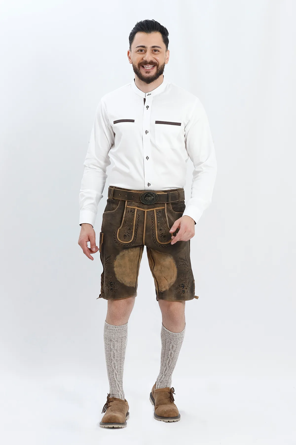 Lederhosen Men in Raw Black with Traditional Bavarian Embroidery. Model is wearing Traditional White Shirt, Bavarian Socks and Smoke Brown Lederhosen Shoes.